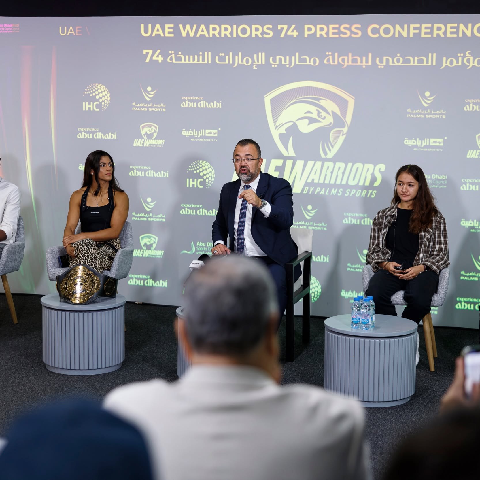 Michele Oliveira and Farida Abdueva on stage with the UAE Warriors strawweight title